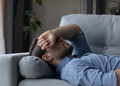 Ein Mann liegt auf der Sofa traurig