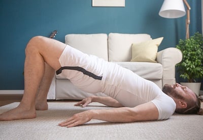 Ein Mann praktiziert Yoga-Übungen für die Beckenbodenmuskulatur.