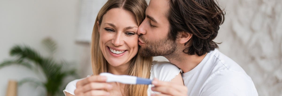 Verliebtes junges Paar freut sich über positiven Schwangerschaftstest