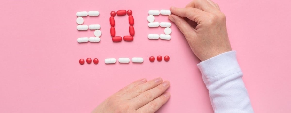 Præventionskoncept med piller, der staver SOS