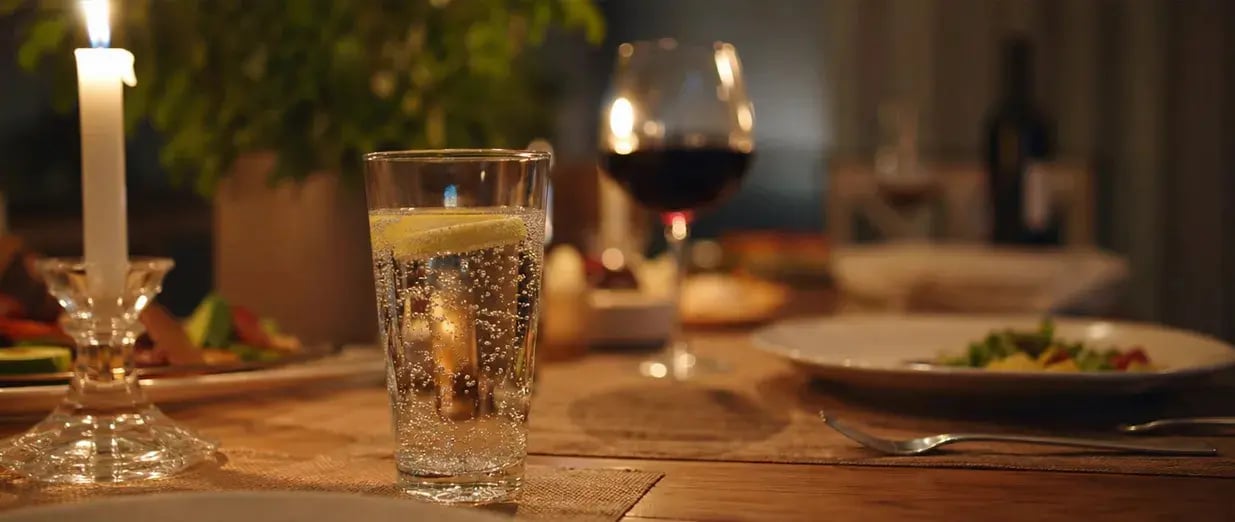 Getr&auml;nke und Abendessen bei Kerzenlicht auf dem Tisch