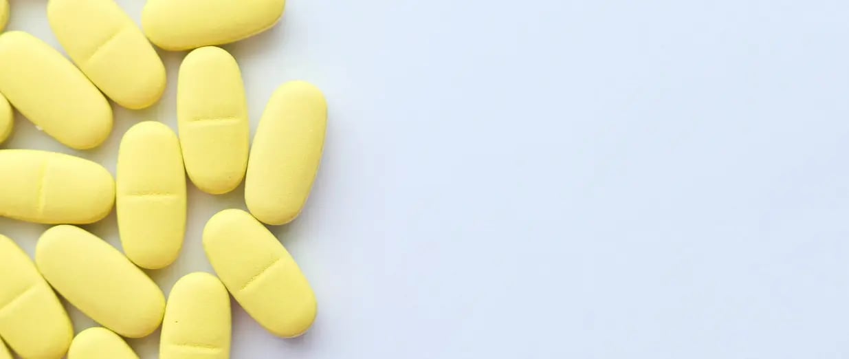 Gelbe Tabletten auf einer wei&szlig;en Oberfl&auml;che