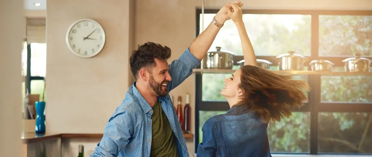 Happy couple dancing together in a kitchen