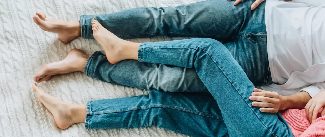 Paar liegt gemeinsam entspannt auf dem Bett