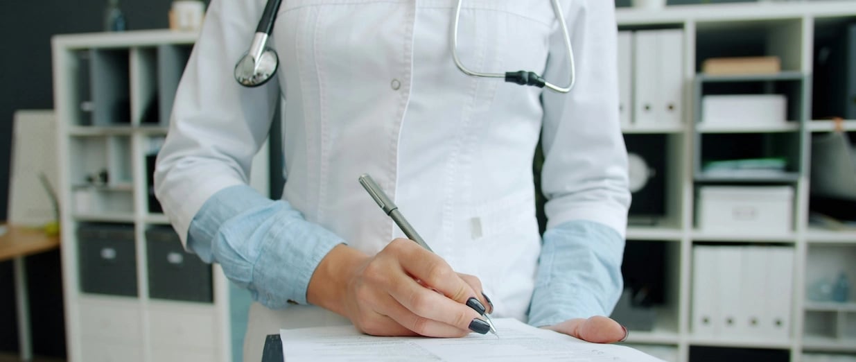 M&eacute;dica escrevendo num espa&ccedil;o em branco