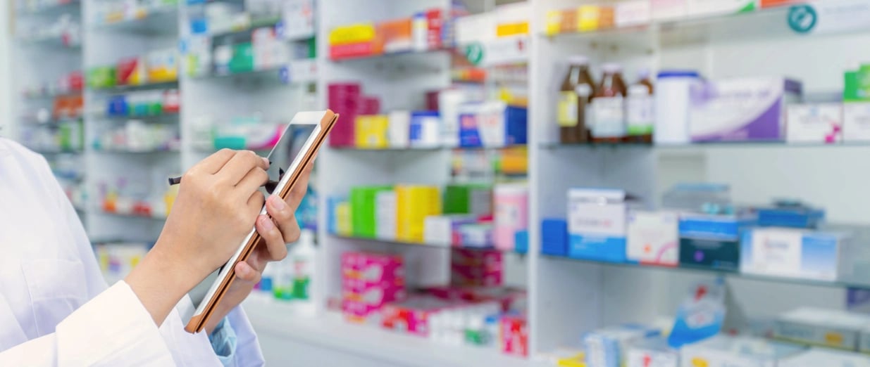 Farmac&ecirc;utico usando um tablet em uma farm&aacute;cia