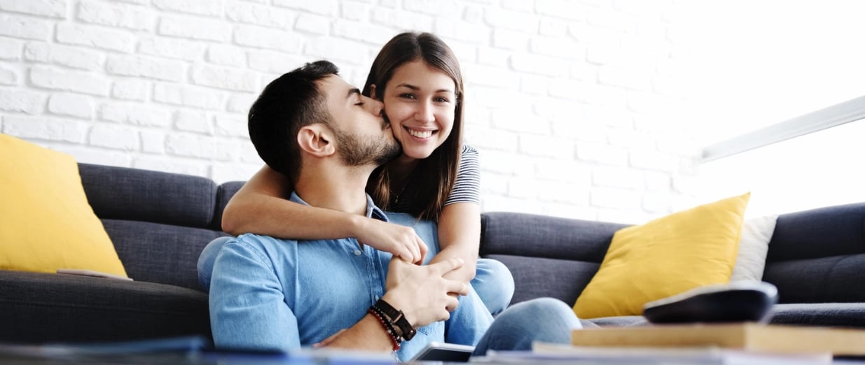 Smiling couple sharing an affectionate moment in a bright living room