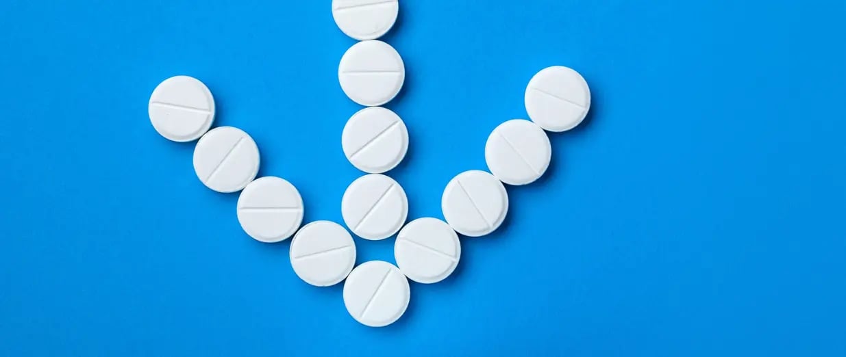 Wei&szlig;e Tabletten auf blauem Hintergrund in Form eines M&auml;nnersymbols