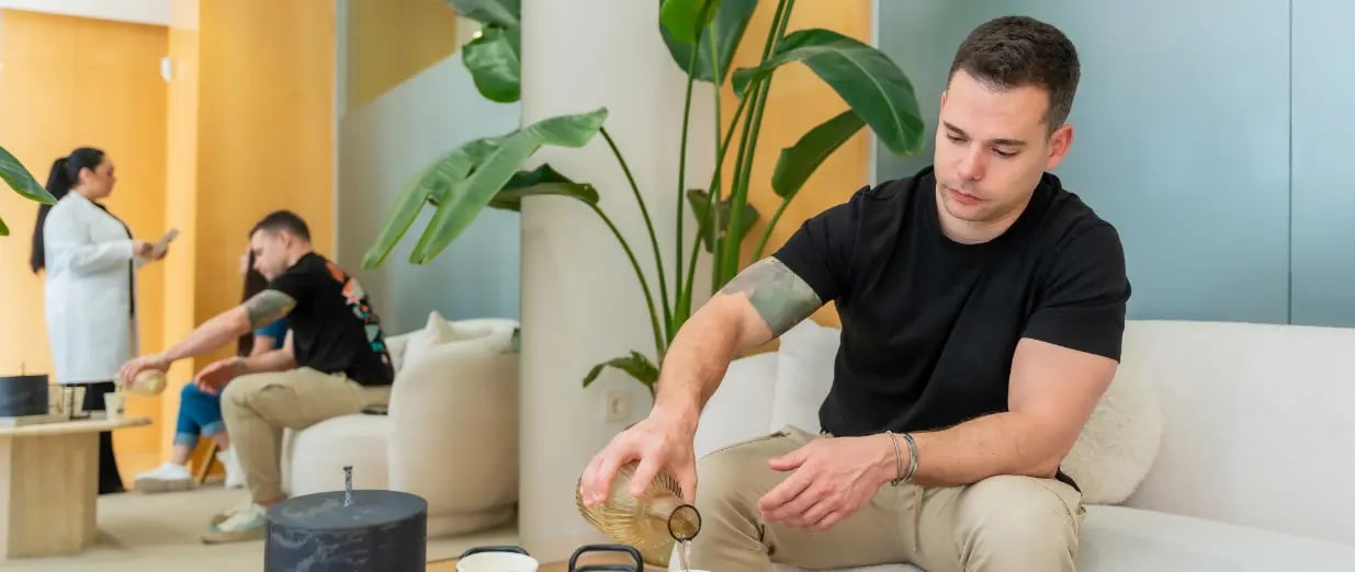 Homem derramando bebida enquanto aguarda consulta m&eacute;dica