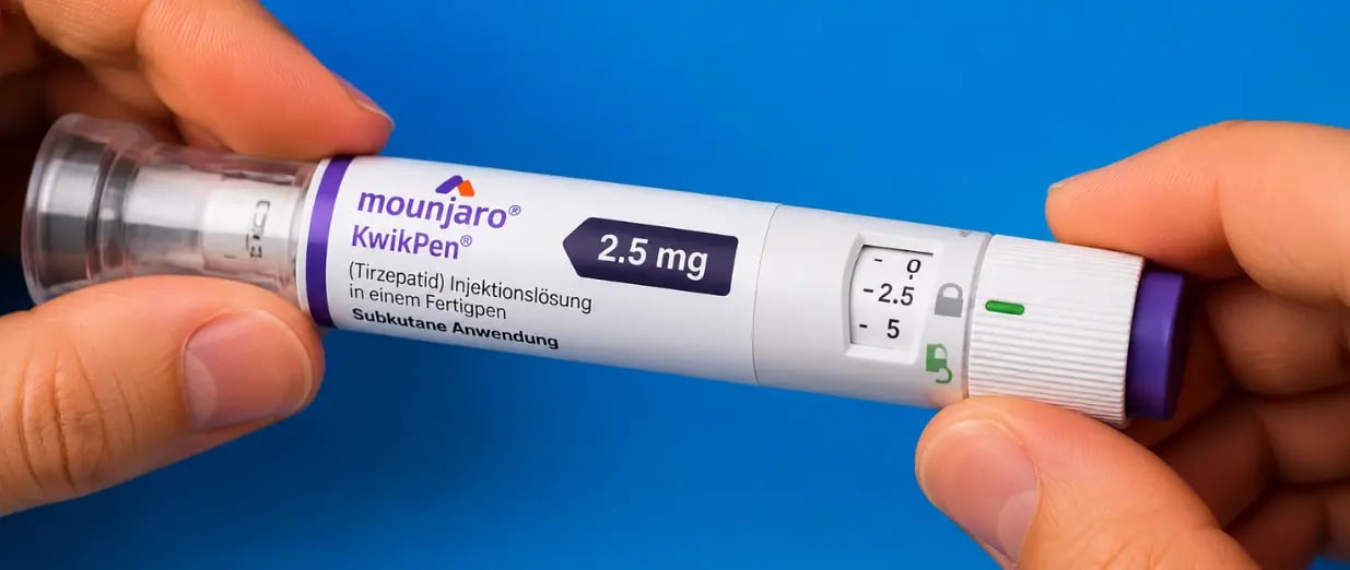 Person h&auml;lt einen Mounjaro KwikPen (2,5 mg) vor blauem Hintergrund