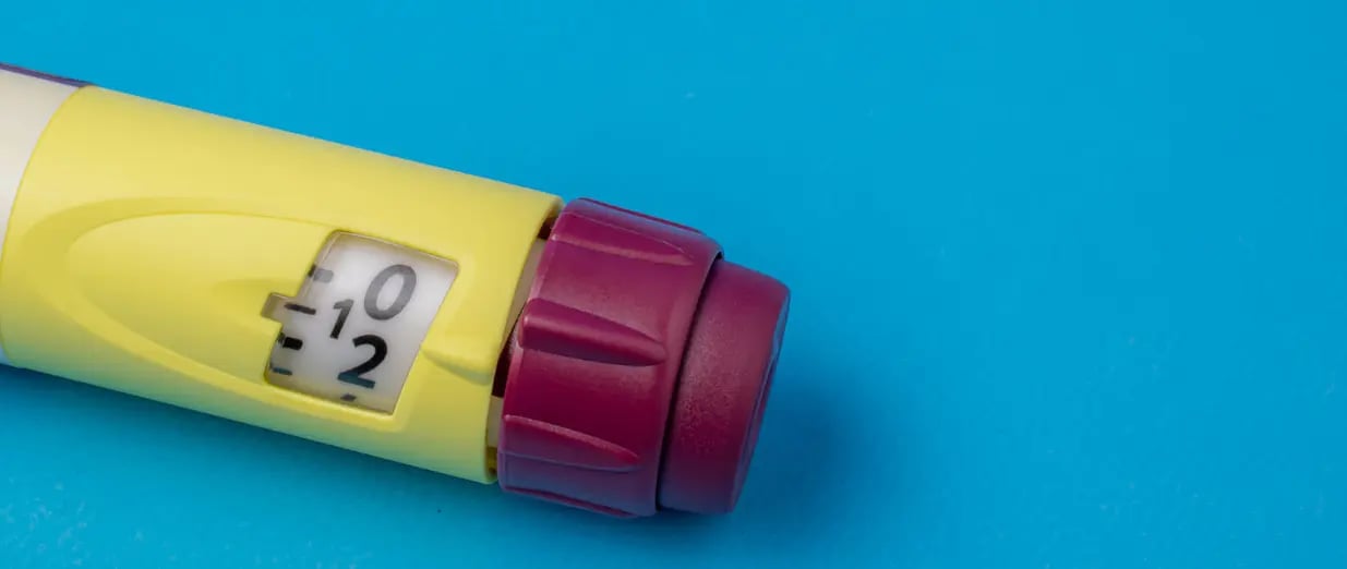 Medizinischer Injektor mit Dosisanzeige auf blauem Hintergrund