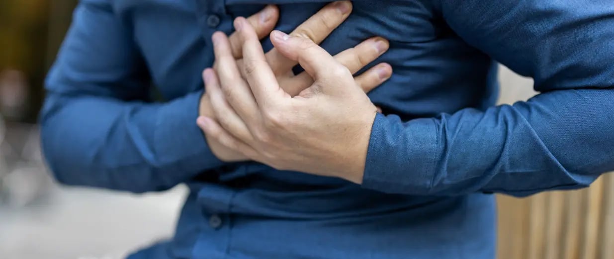 Person h&aring;ller handen mot br&ouml;stet