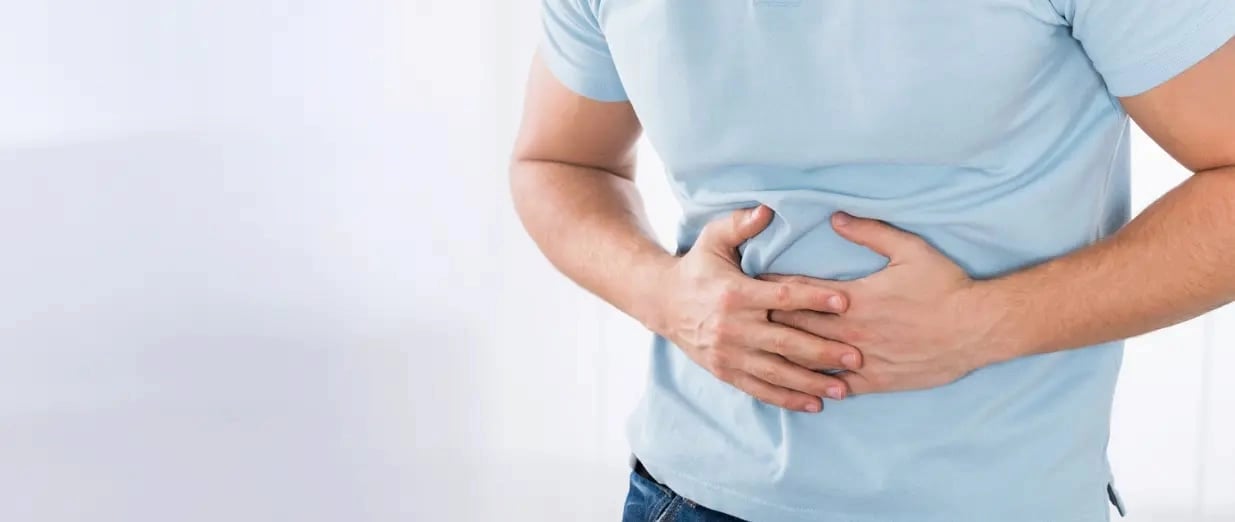 A man is clutching his stomach in pain