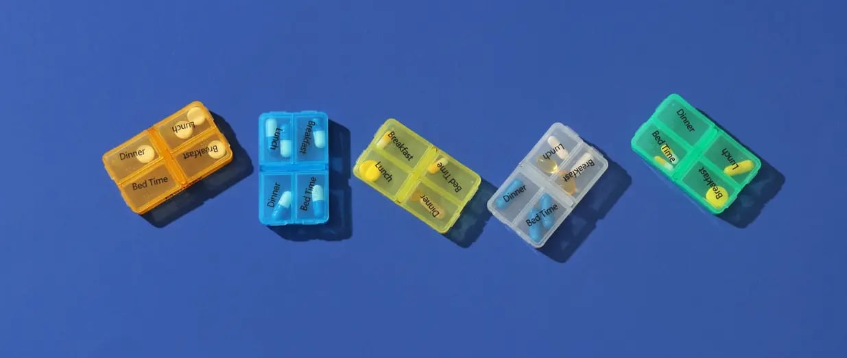 Bunte Medikamentenboxen auf blauem Hintergrund