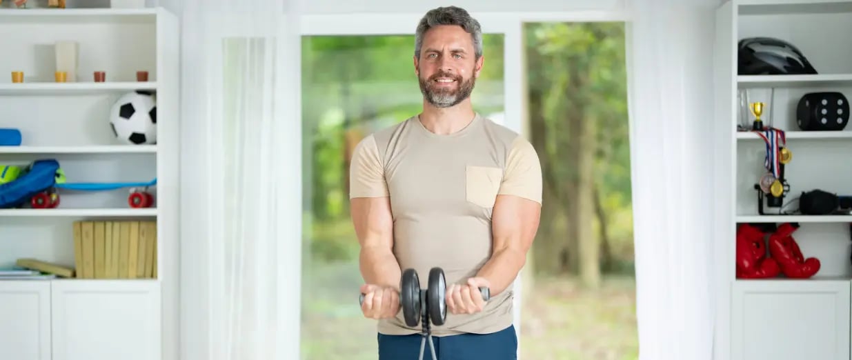 Mann trainiert mit Hanteln zu Hause