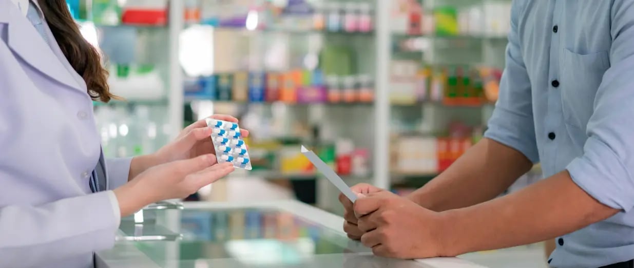 Apothekerin &uuml;bergibt einem Kunden Medikamente