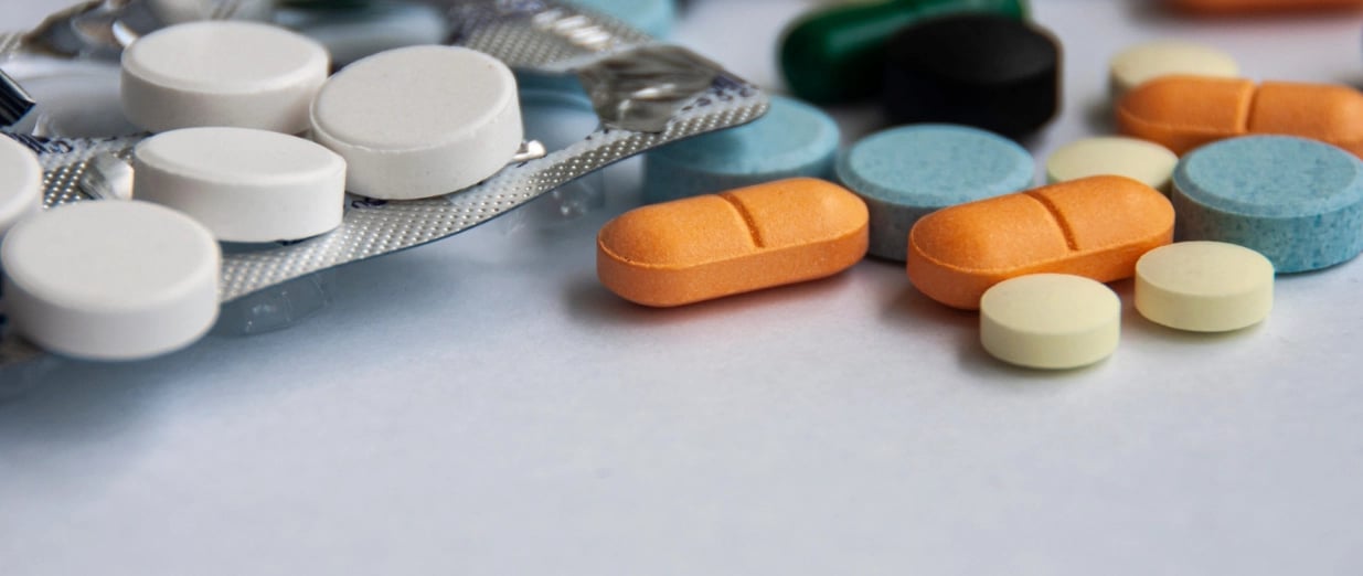 Verschiedene Tabletten und Kapseln auf weißem Hintergrund