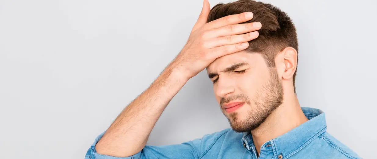 Mann mit Kopfschmerzen h&auml;lt sich die Stirn