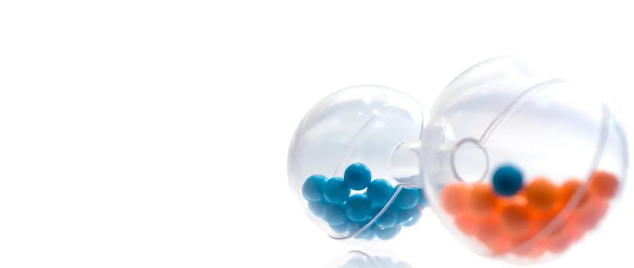 Blaue und orangefarbene Pillen aus transparenten Kapseln auf weißem Hintergrund