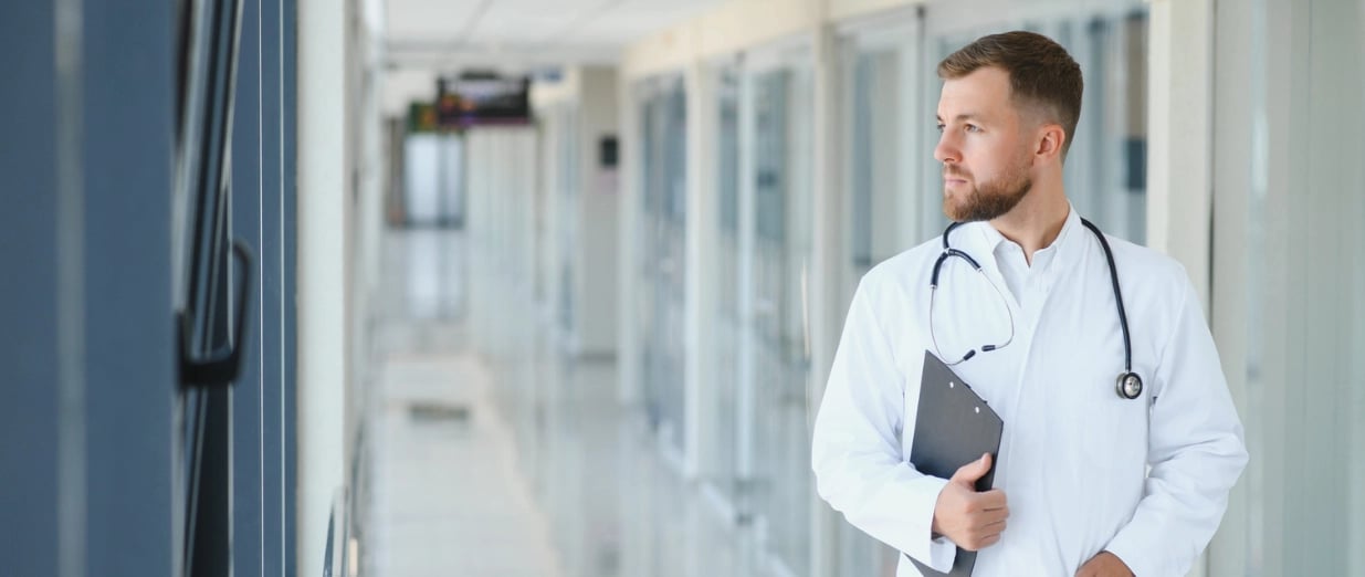 Doctor in a hospital hallway holding a clipboard