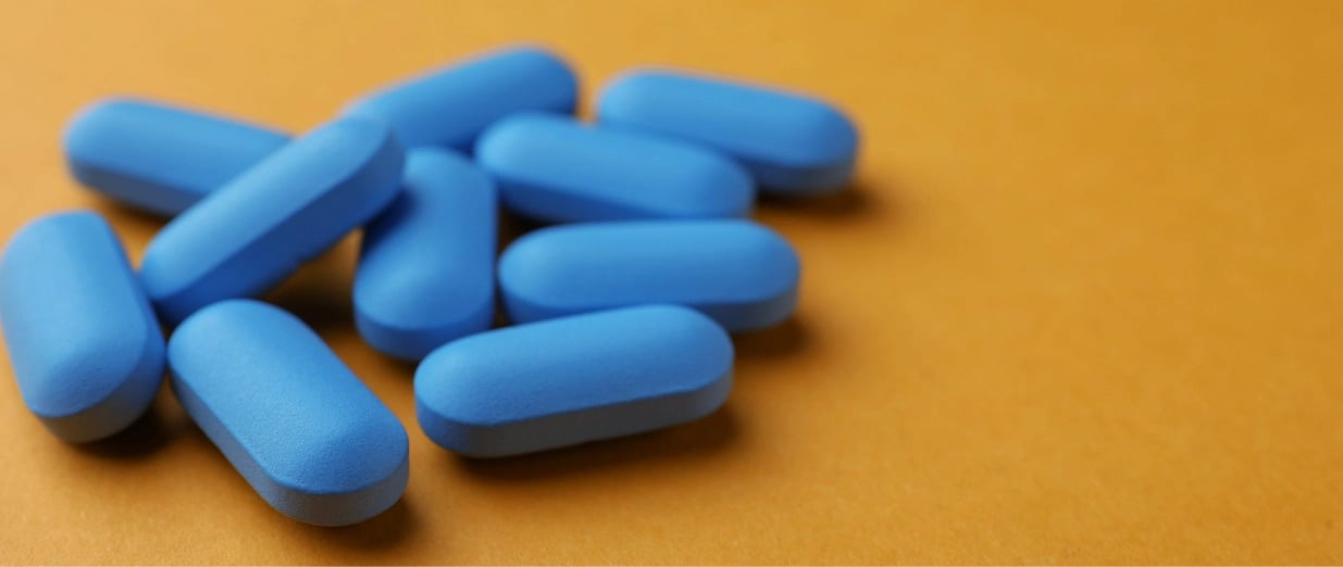 Blaue Tabletten auf einem orangefarbenen Hintergrund
