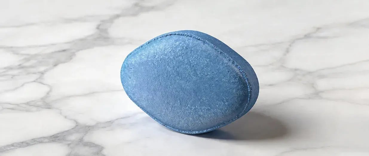 Comprimido azul sobre uma superf&iacute;cie de m&aacute;rmore