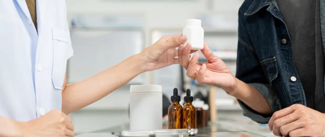 Eine Apothekerin verkauft einem Kunden Medikamente