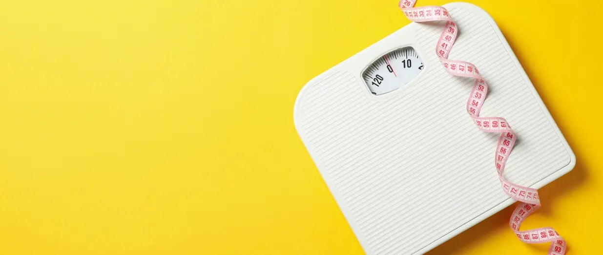 Balance avec m&egrave;tre ruban sur fond jaune