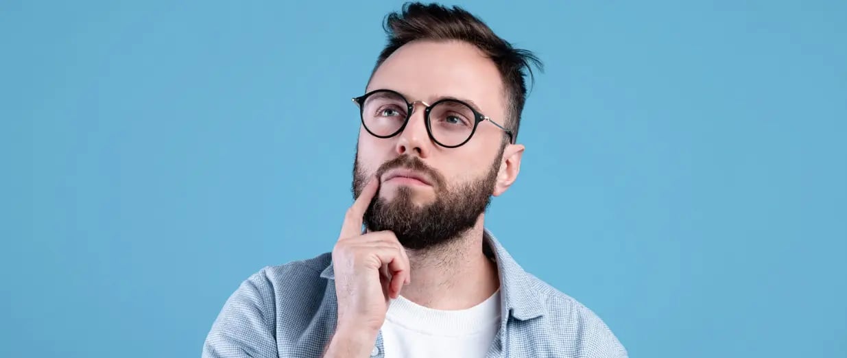 Nachdenklicher Mann mit Brille blickt nach oben