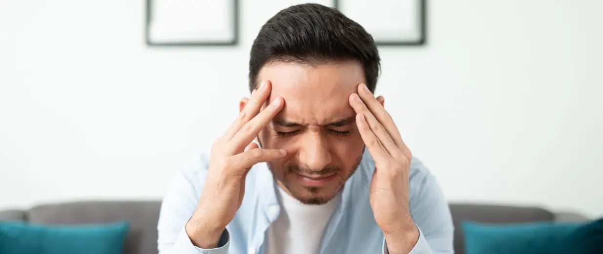 Mann h&auml;lt sich den Kopf und leidet unter Kopfschmerzen