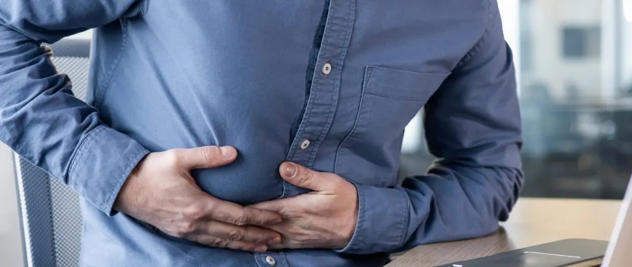 Person h&auml;lt sich wegen Bauchschmerzen den Bauch