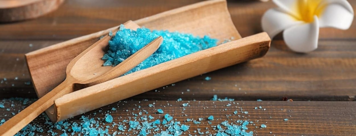Schaufel mit blauem Salz auf einem Holztisch