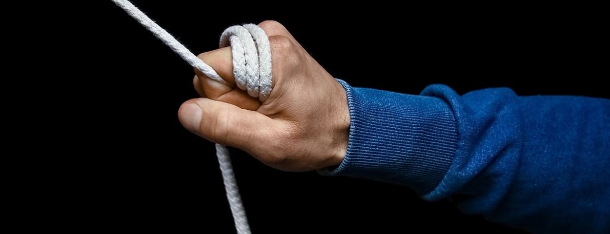Die Hand eines Mannes, die ein Seil umklammert