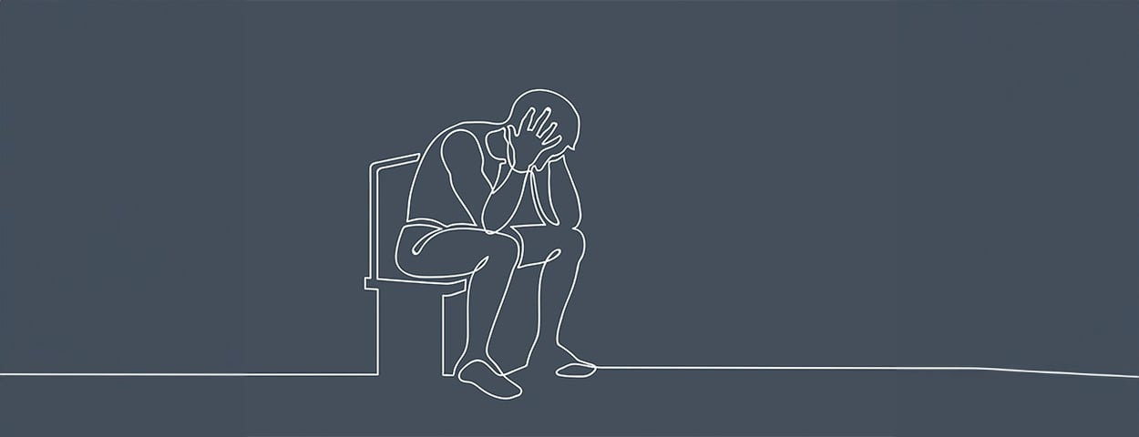 Ein Mann sitzt unglücklich auf der Toilette