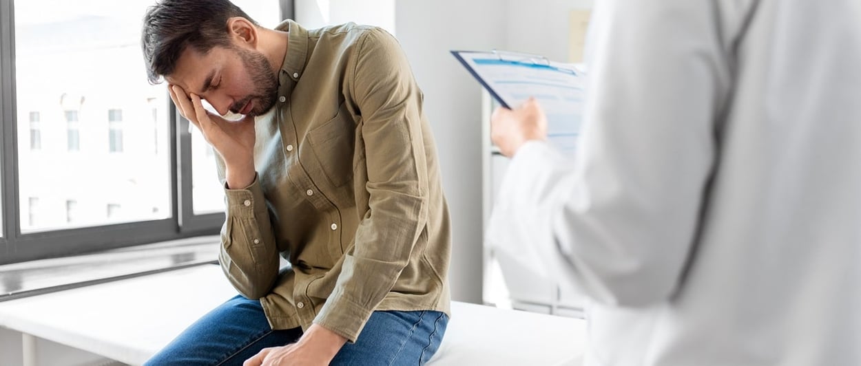 Ein trauriger Mann, der wegen Ejakulationsproblemen zum Arzt geht