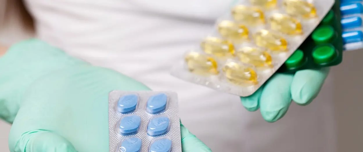 Uma enfermeira segurando dois tipos de medicamentos para impotência