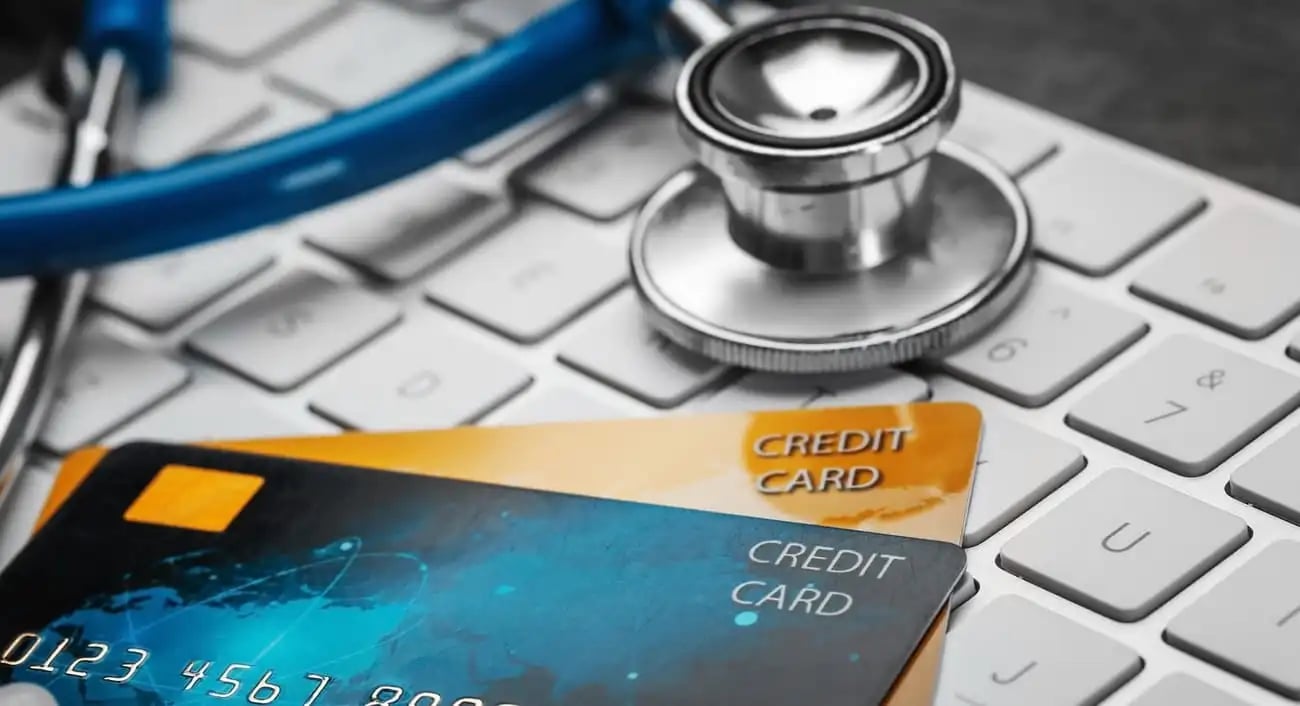 Stethoskop und Kreditkarten auf einer Computertastatur &ndash; ein Konzept f&uuml;r den Online-Kauf von Potenzmitteln