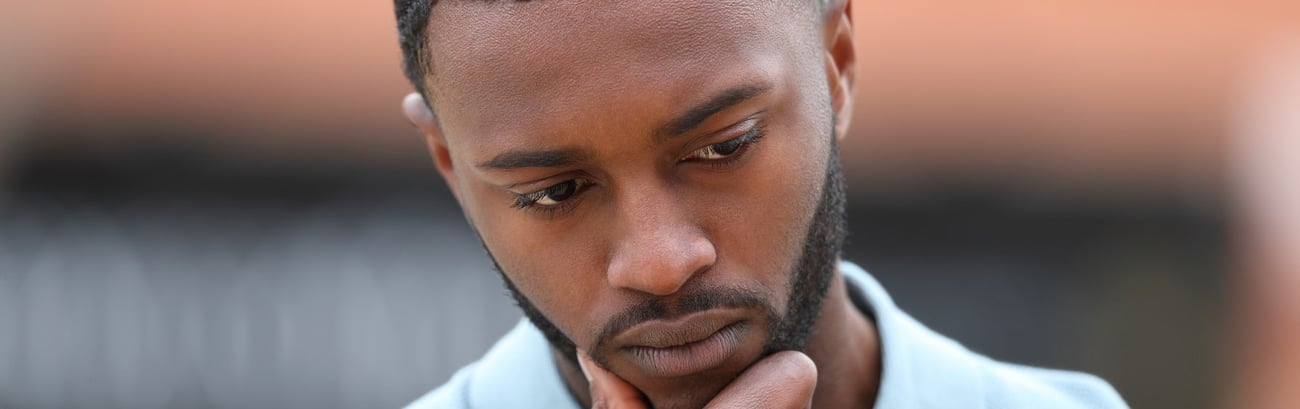 Ein besorgter afrikanischer Mann denkt darüber nach, ob er eine erektile Dysfunktion hat