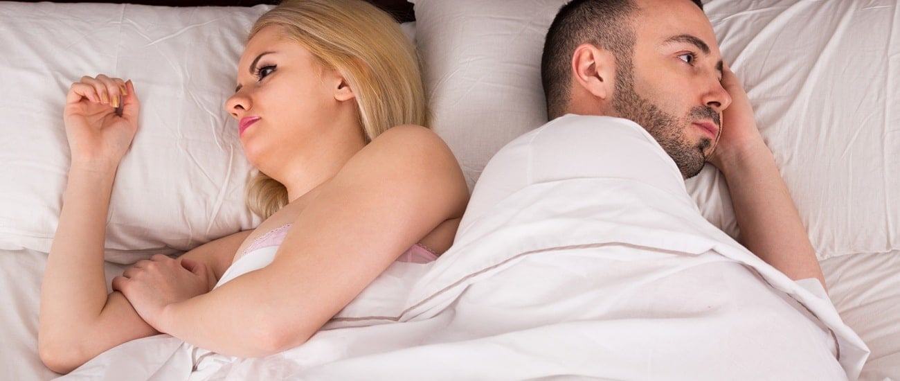 Young man and young woman with sexual problems in bed