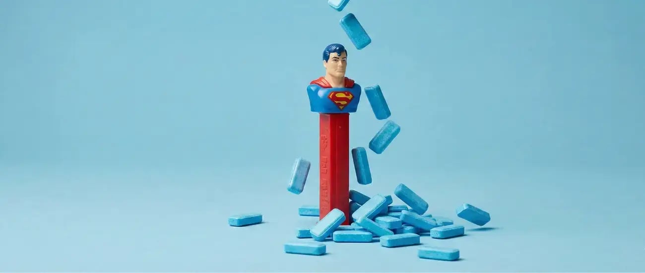 Superman-Bleistift, umgeben von vielen blauen Pillen