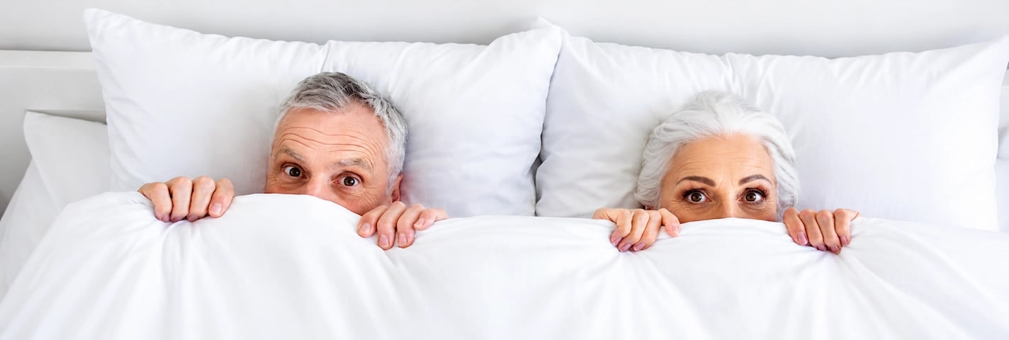  Um casal na cama, surpreendido com o desempenho sexual do homem.