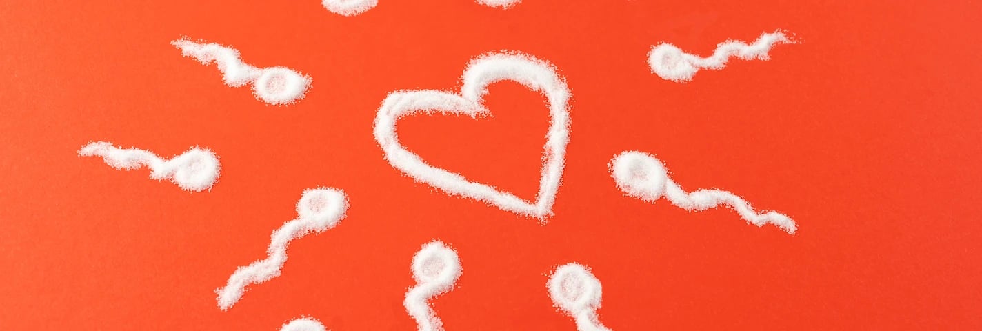 Coração formado por espermatozoides sobre um fundo vermelho