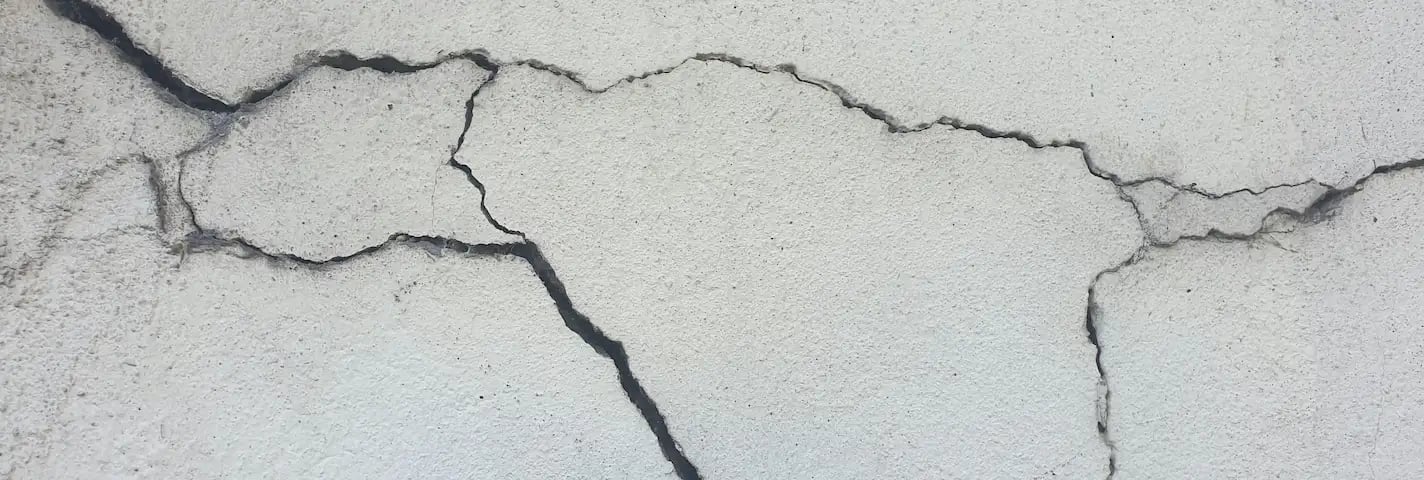 Racha numa parede de cimento branco