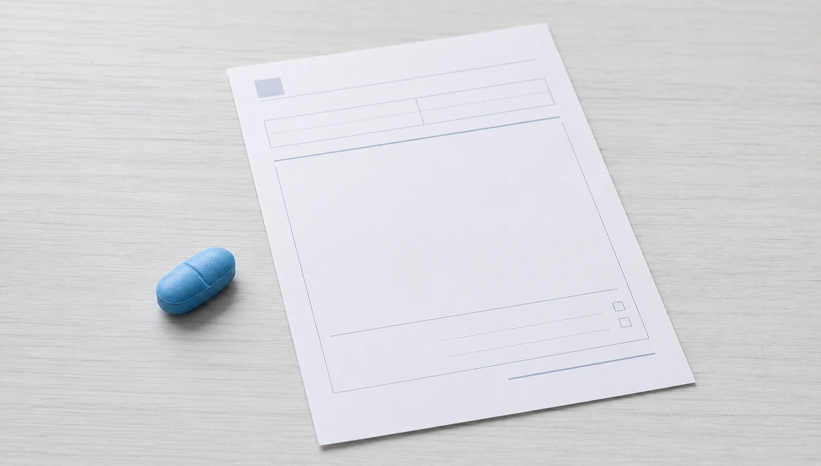 Un comprimé bleu à côté de la fiche d'un médecin