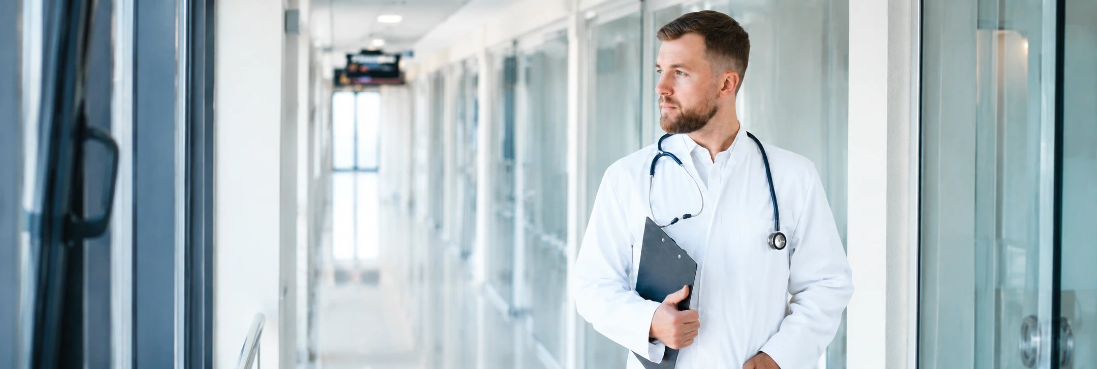 Doctor in a hospital hallway holding a clipboard