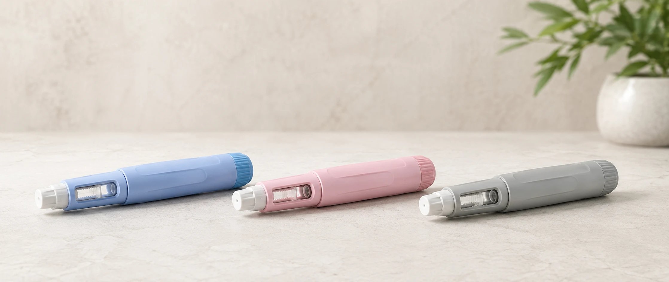 Three different injection pens on a table
