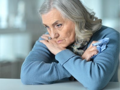 Eine ältere Frau, die aufgrund von altersbedingten hormonellen Veränderungen depressiv ist