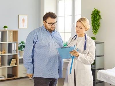 Ein übergewichtiger Mann wird von einer Ärztin untersucht