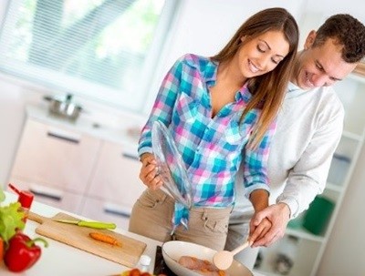 Um casal cozinha uma refeição romântica e saudável
