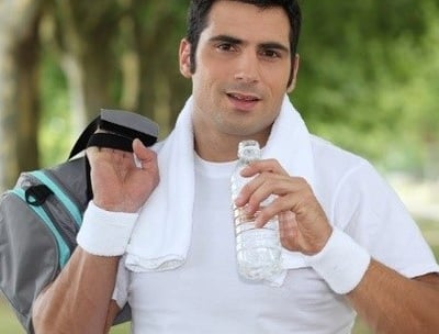 Um homem bonito a beber água depois do exercício